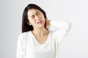 女性が首を抑えている