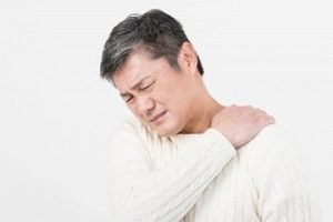 男性が肩を抑えている